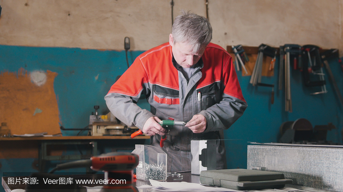 工人用钳子、打磨金属和金属细节的工具手工组装金属零件